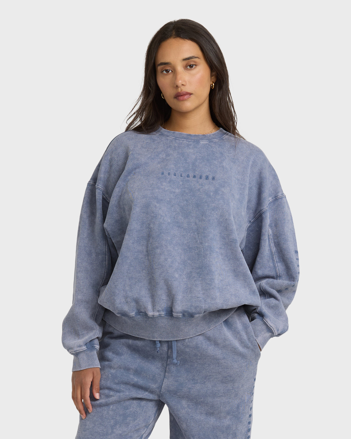 Stone blue crewneck sweatshirt with saltwashed finish and embroidered text on chest, shown on model.
