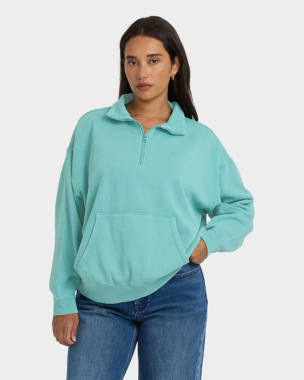 Turquoise half-zip sweatshirt with collar and front kangaroo pocket, worn with blue jeans.