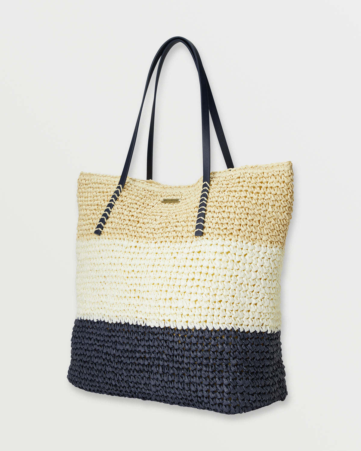 Woven straw tote bag with colorblock design in natural, cream, and black sections with dark shoulder handles.