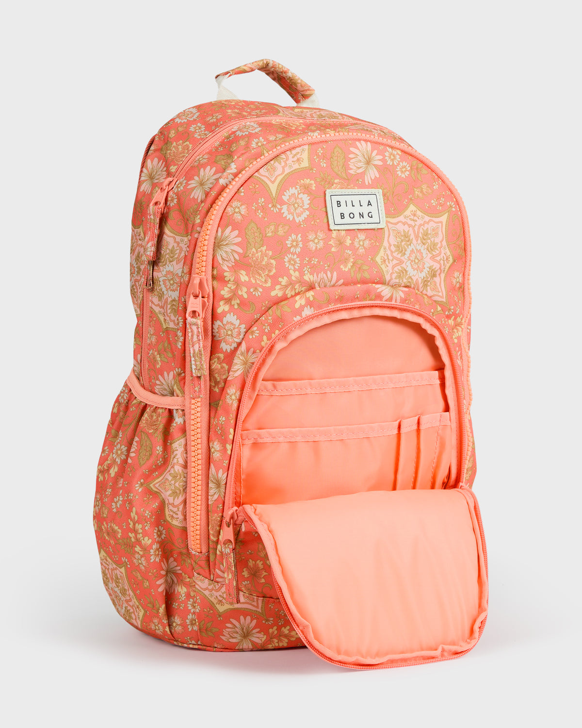 Coral backpack with floral print, front zippered pocket open showing compartments, Billabong brand label visible.