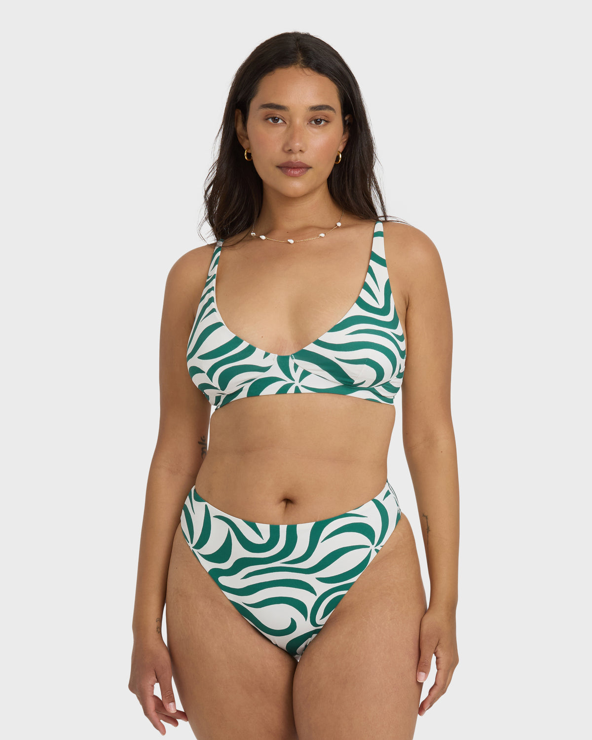 Evergreen and white wave-patterned bikini bottom with high-rise cut on model.