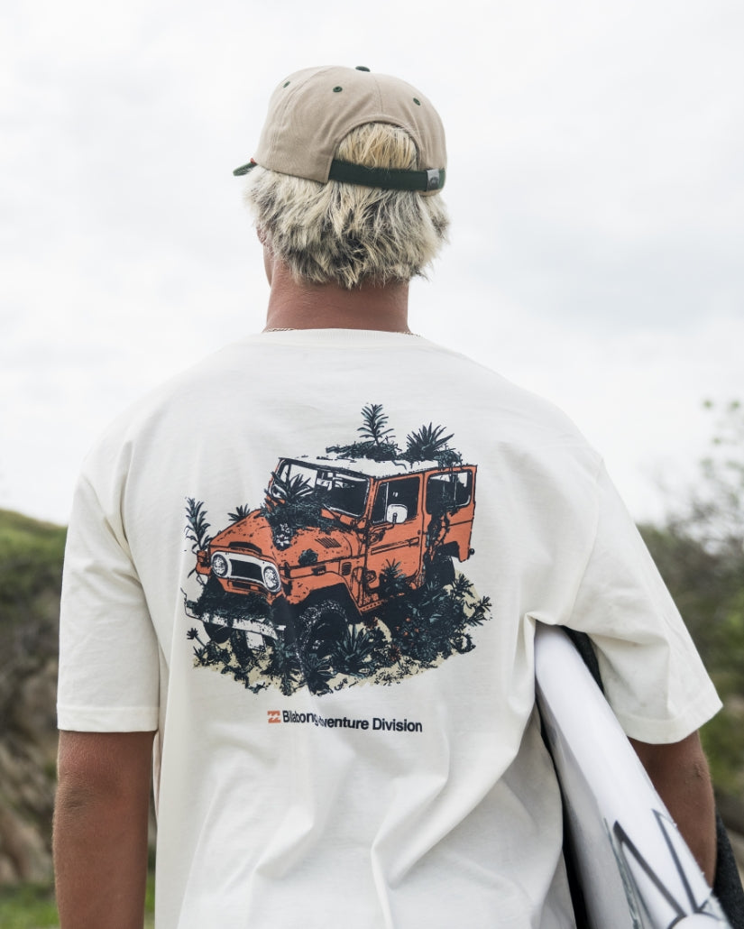 Off-white short sleeve t-shirt with orange and black illustration of a vehicle with palm trees and "Adventure Division" text 