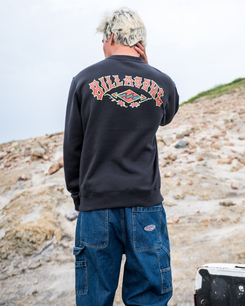 Washed black crewneck sweatshirt with red and white graphic print on back, worn with blue cargo jeans.