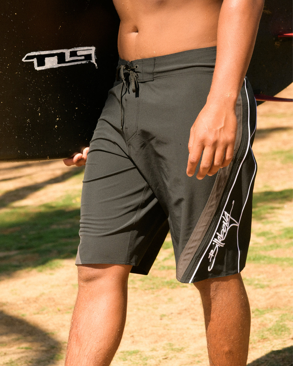 Black boardshorts with white stripe details down the side seam and drawstring closure.