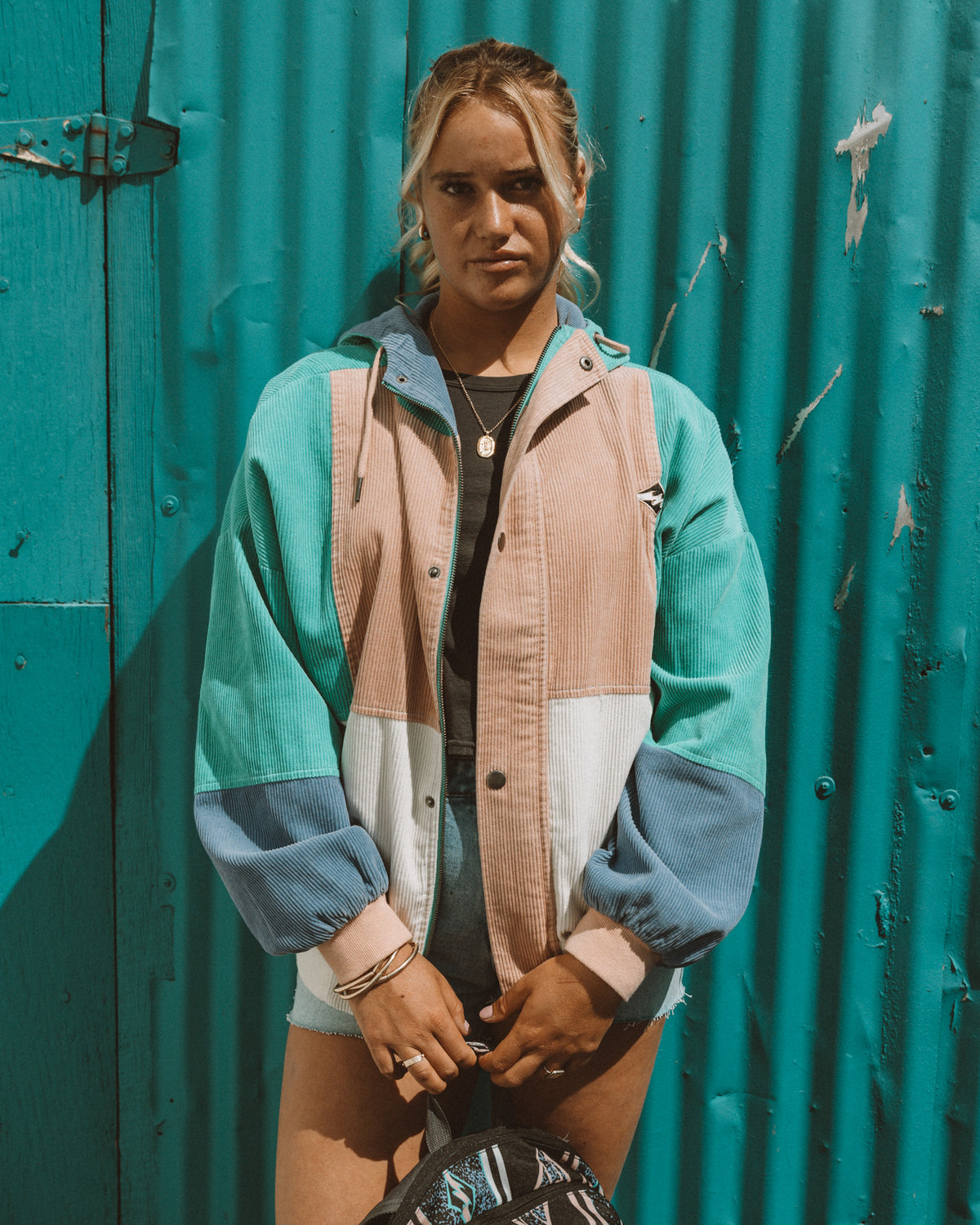 Aqua haze jacket with color-blocked panels in teal, cream, and blue, featuring a collared neckline and button front.