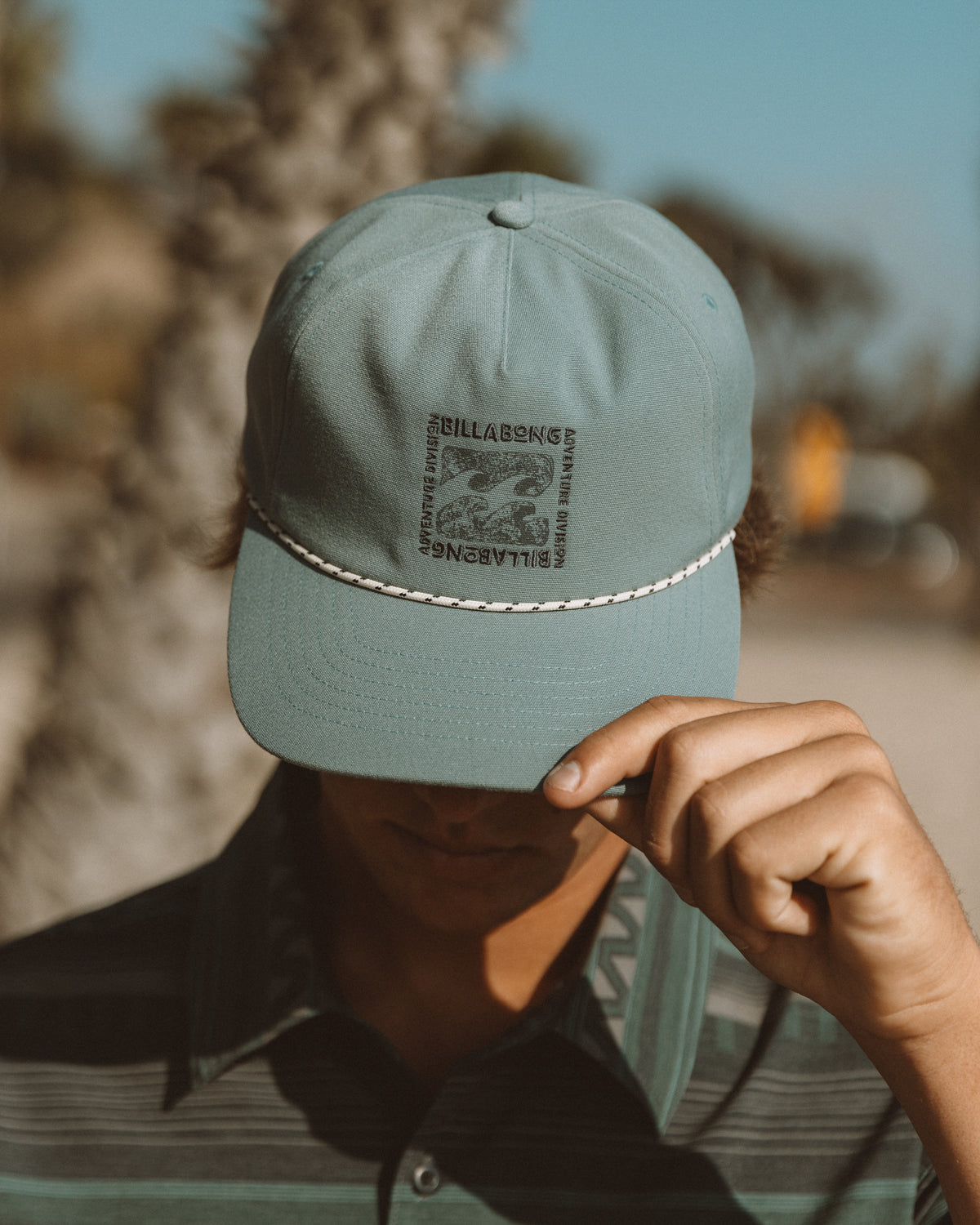 Sea blue strapback hat with Billabong logo and white rope trim detail.