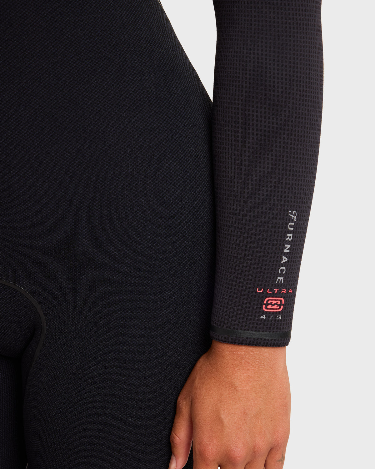 Black full-length wetsuit with textured neoprene showing chest area, sleeve, and brand branding on arm.