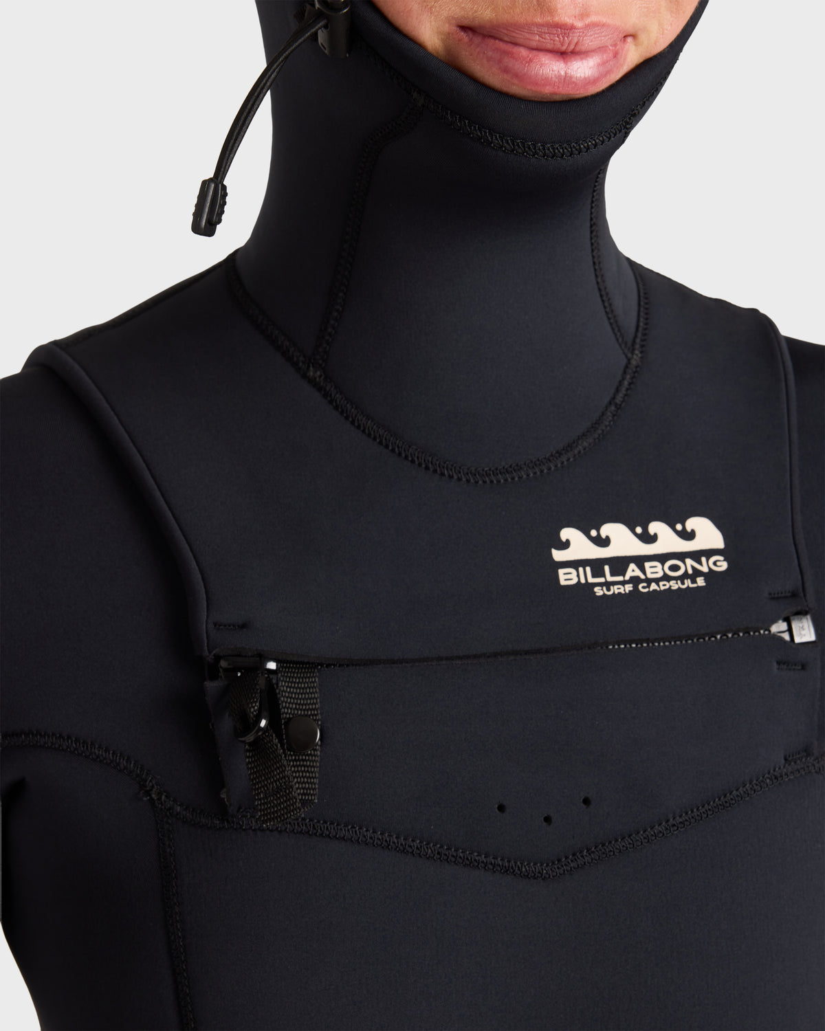Black full-length wetsuit with chest zip closure and hood, featuring Billabong branding on chest.