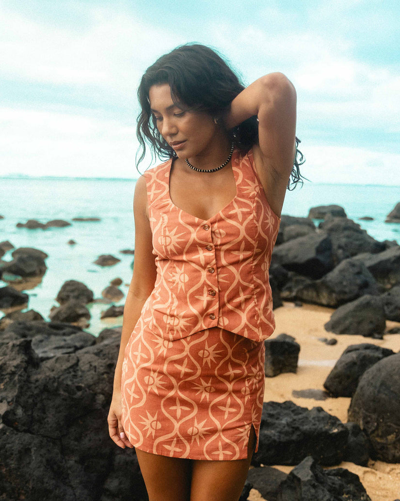 Dark coral sleeveless vest with geometric pattern and button front, worn over matching dress.