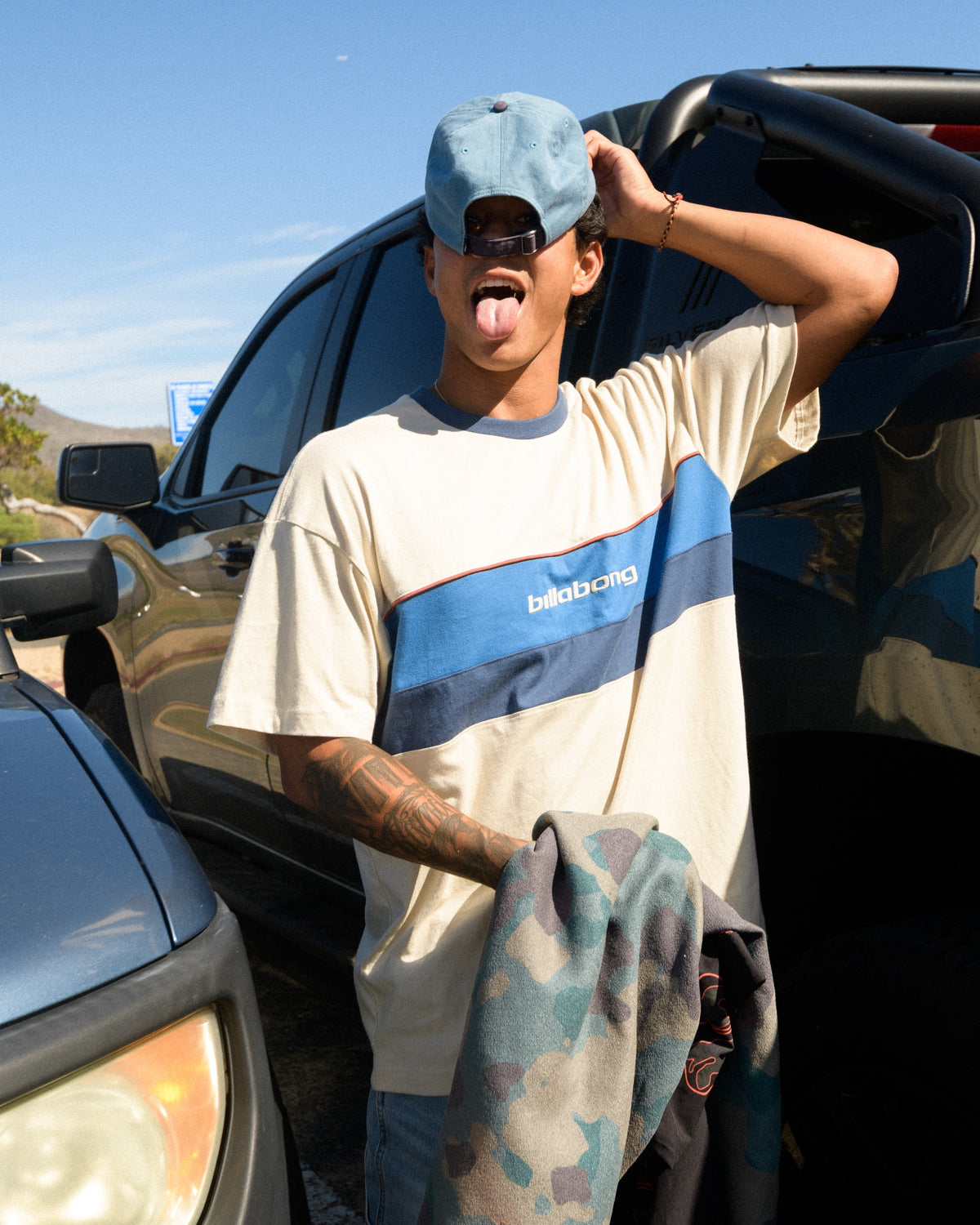 Oatmeal short-sleeve crew t-shirt with blue and navy horizontal stripe and "billabong" text on chest.