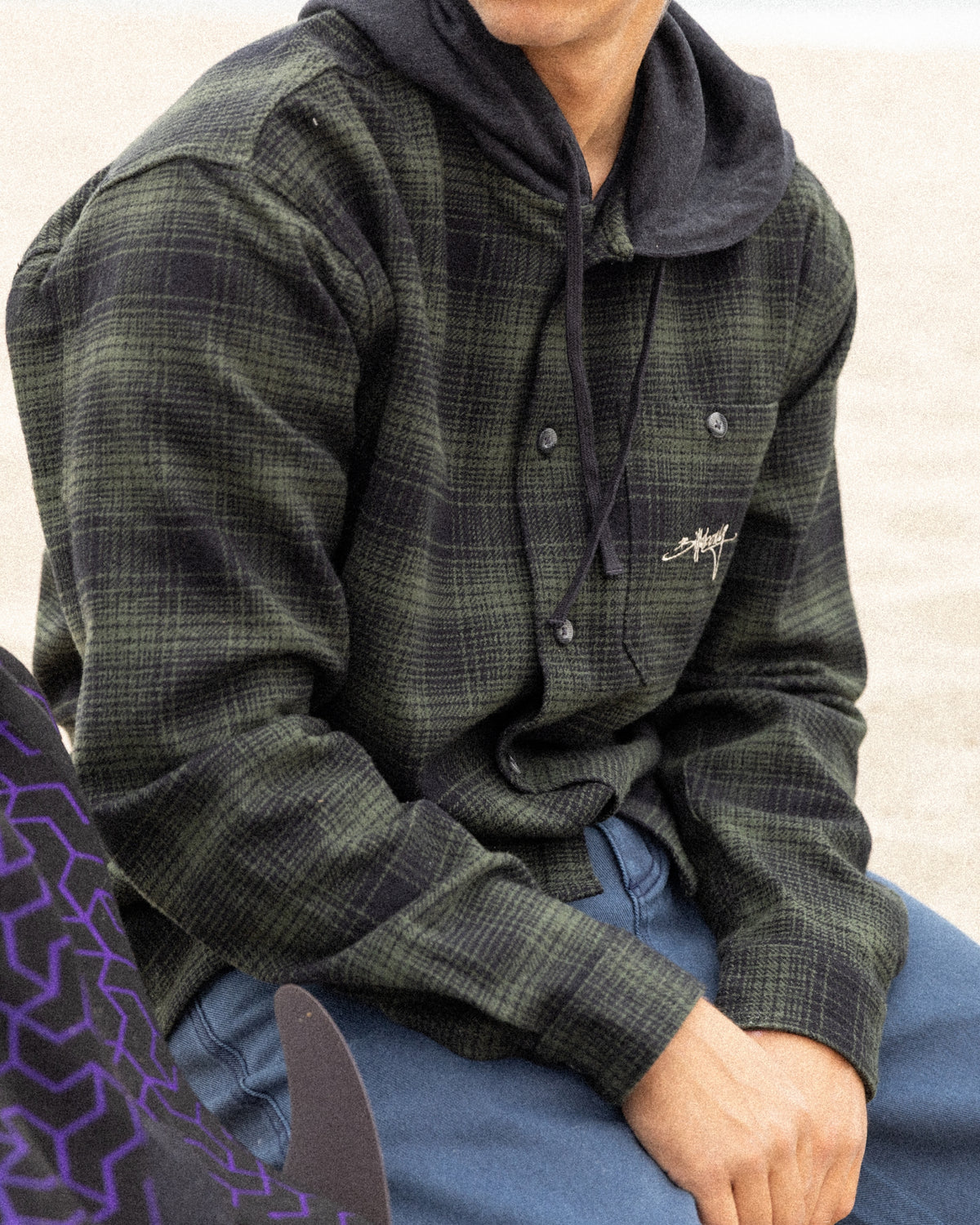 Black and gray plaid flannel shirt with collar and button front on model.