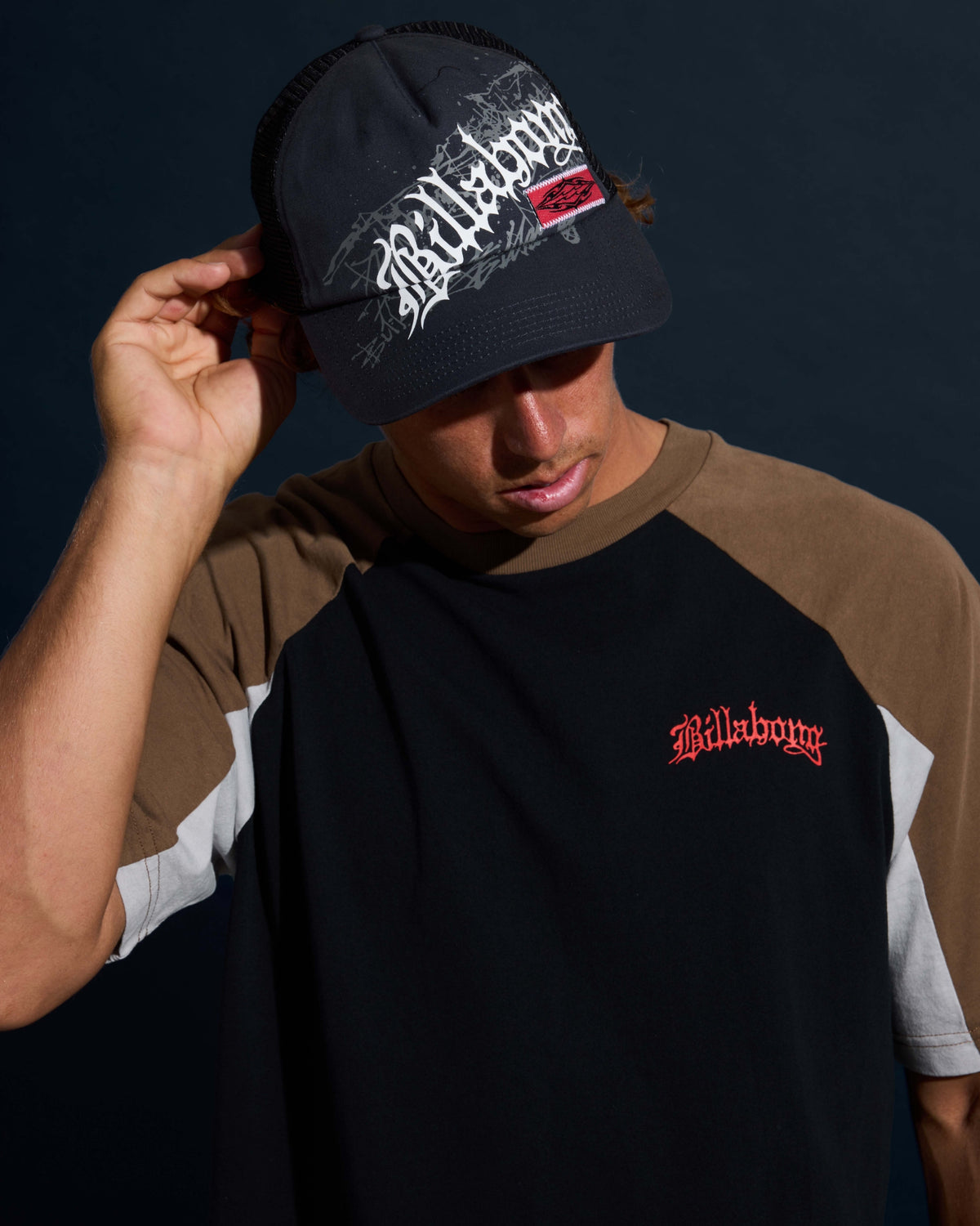 Black short sleeve t-shirt with red text graphic on chest and tan and white raglan sleeves.