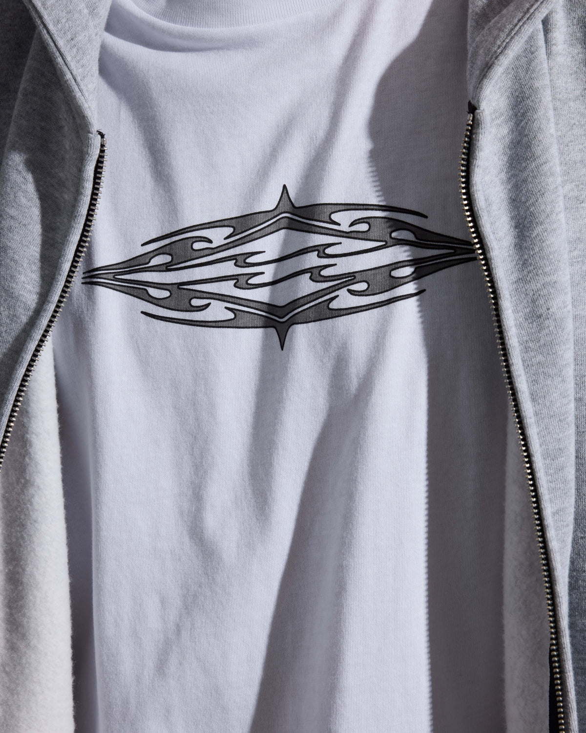White short sleeve knit t-shirt with black tribal diamond graphic on chest.