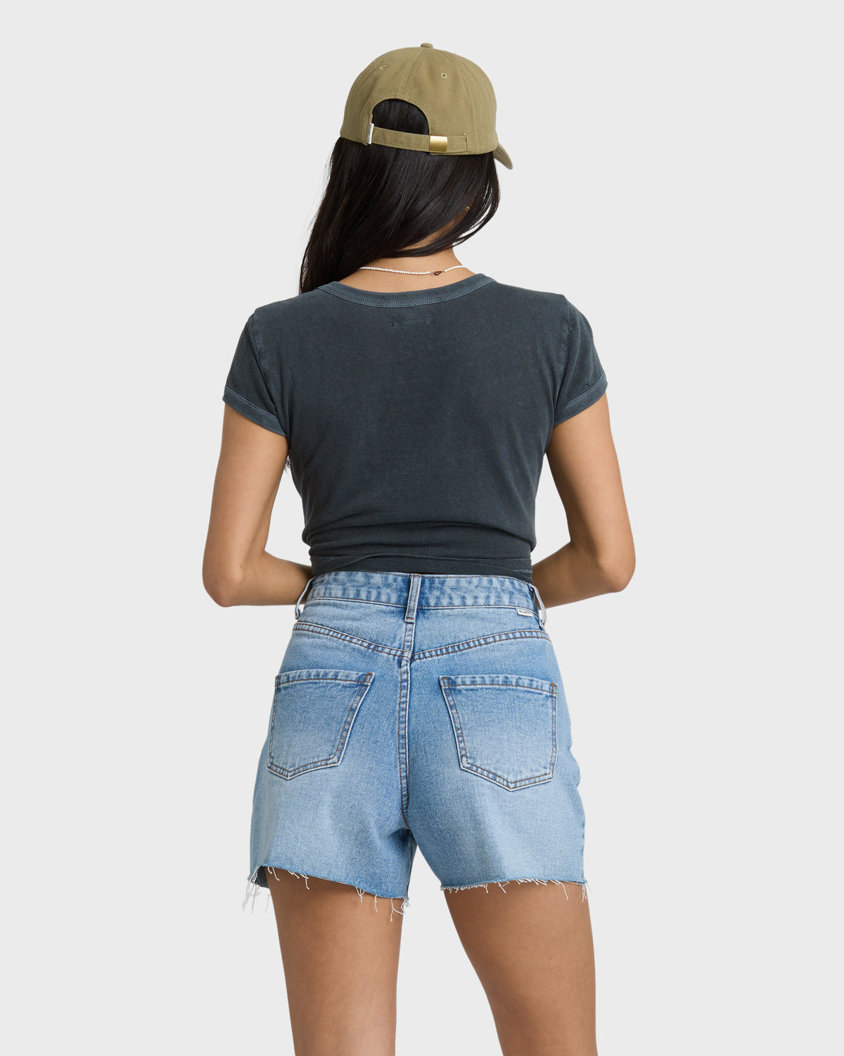 Faded indigo denim cut-off shorts with frayed leg openings and visible stitching details, shown from the back.
