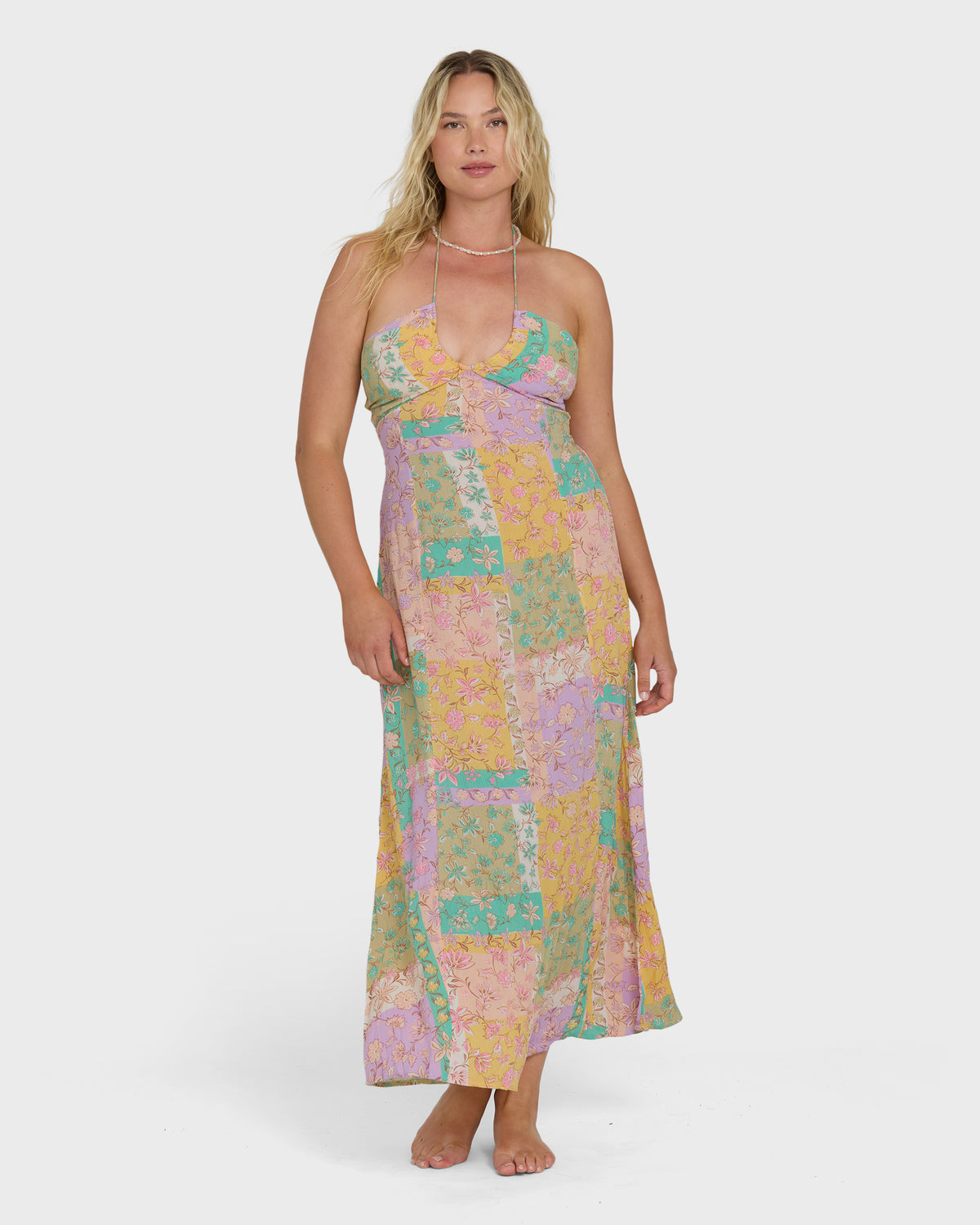 Sleeveless halter maxi dress in patchwork floral print with pink, yellow, green, and purple tones.