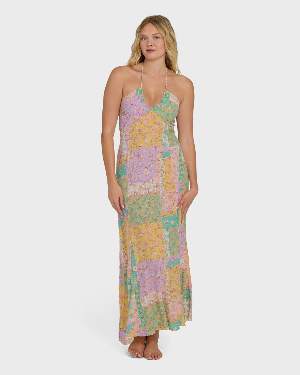 Halter maxi dress in violet, yellow, and green patchwork floral print with full-length skirt.
