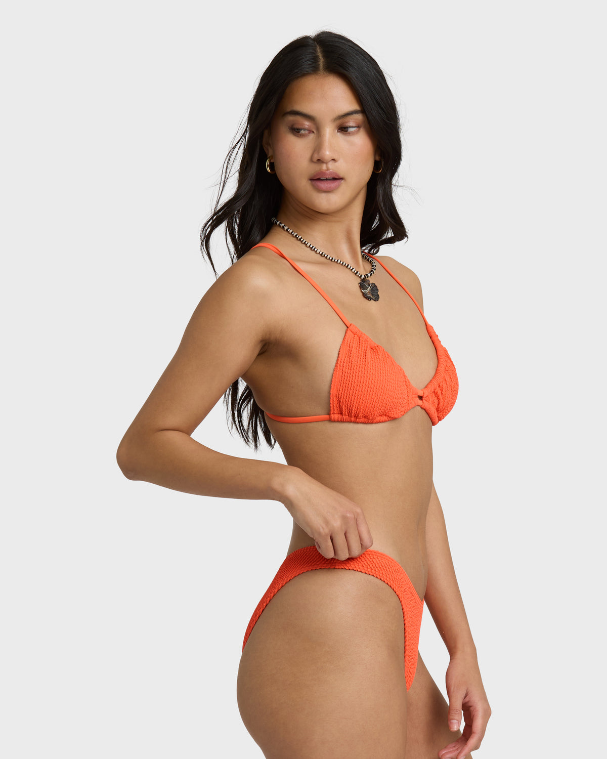 Hot coral textured bikini bottom with side tie closure, shown on model wearing matching top.