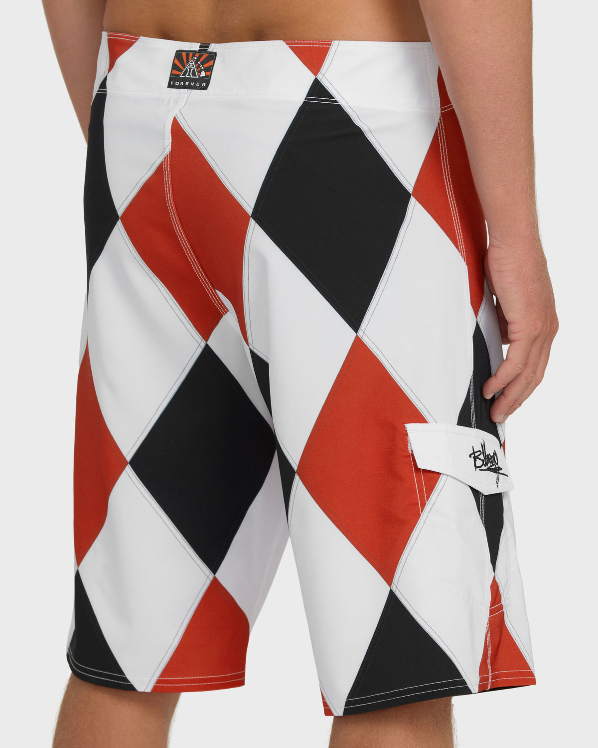 Red, white, and black diamond-patterned boardshorts with side pocket and brand label visible.