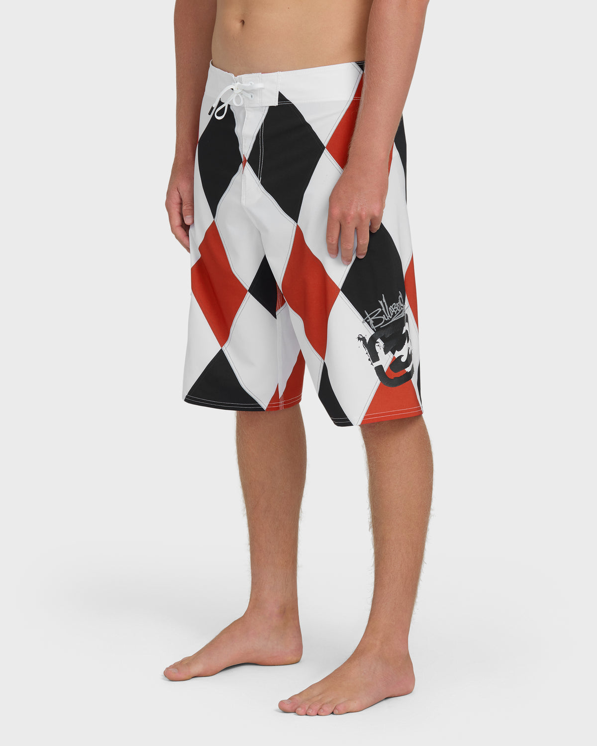 Red, black, and white diamond-patterned boardshorts with drawstring waist and graphic design on leg.
