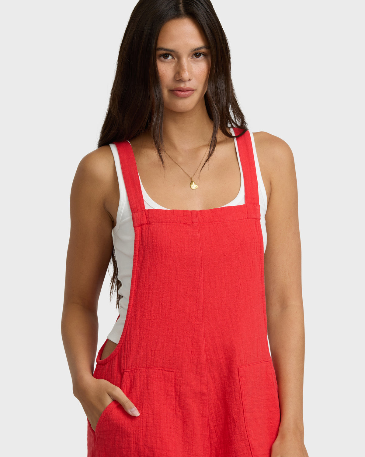 Red and white sleeveless romper with square neckline, side cutouts, and front pockets on model.