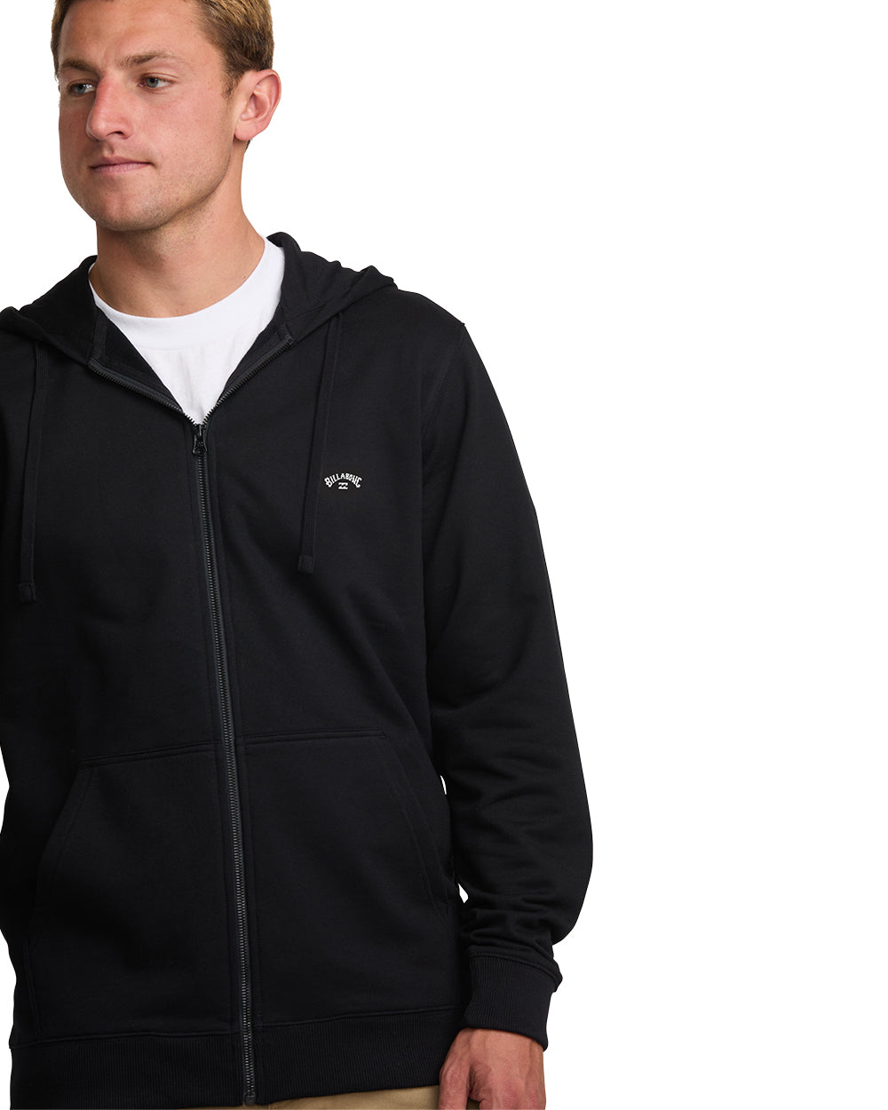Man wearing black zip-front hoodie with white t-shirt underneath and drawstring hood.