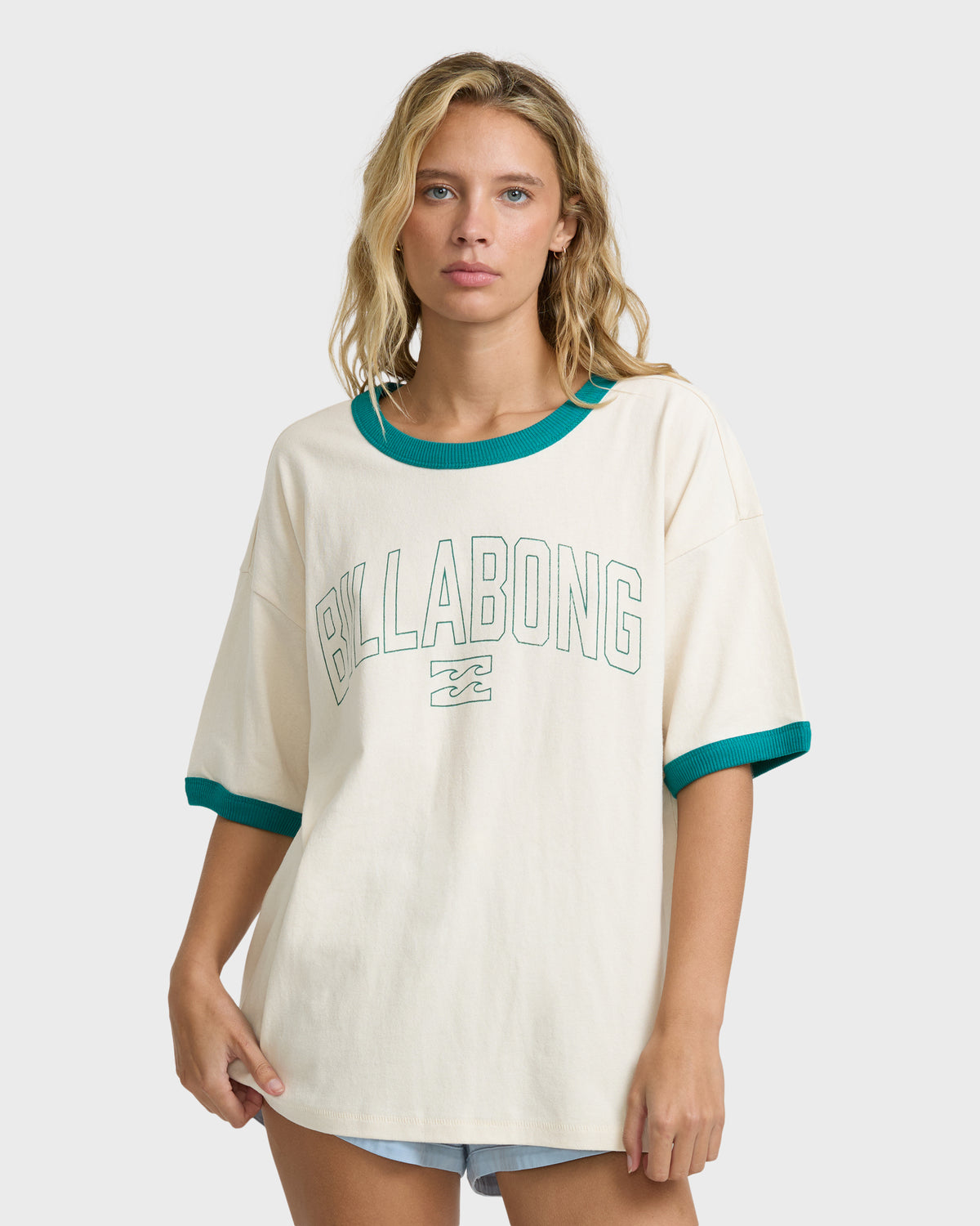 White short-sleeve ringer t-shirt with teal ribbed neckline and cuffs, "Billabong" graphic print on chest.