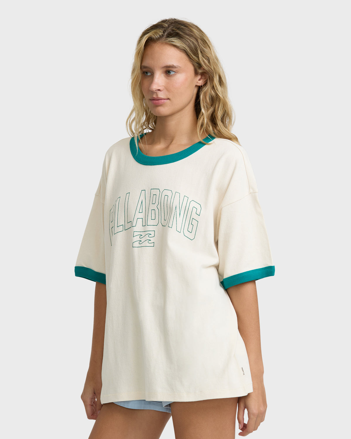 White short-sleeve knit t-shirt with teal ribbed neckline and cuffs, featuring "Billabong" text on chest.