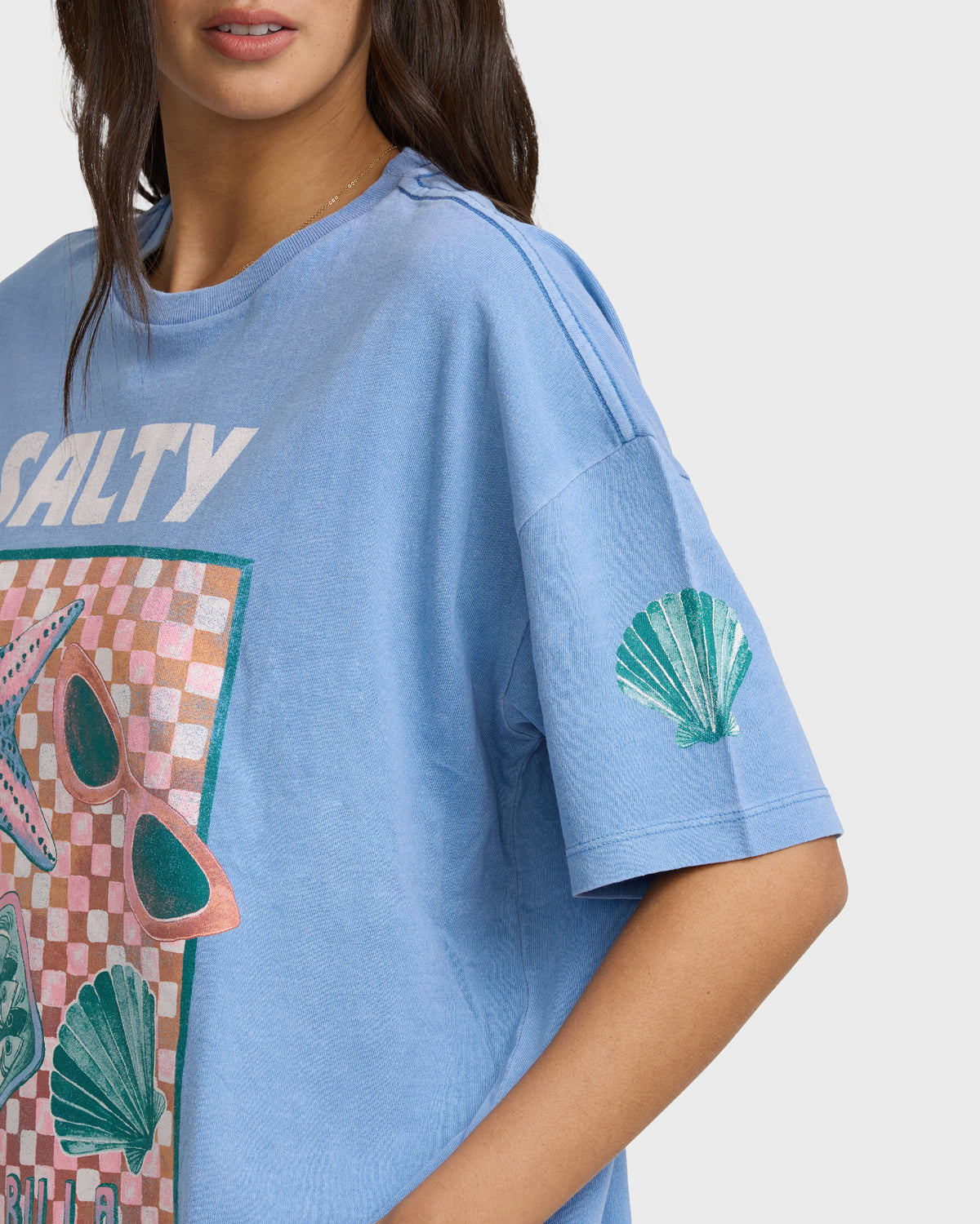 Blue short-sleeve cotton t-shirt with "Salty" text and graphic print featuring sunglasses and shell motifs.