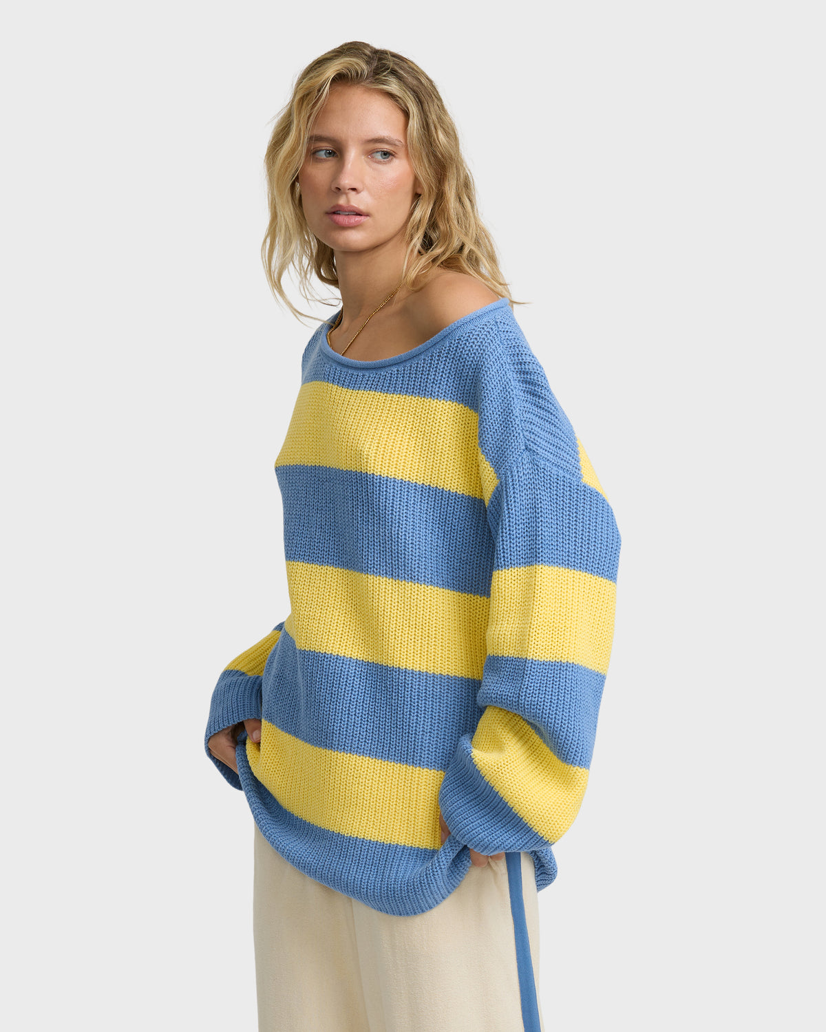 Blue and yellow striped off-shoulder knit sweater with textured fabric and dropped sleeves.