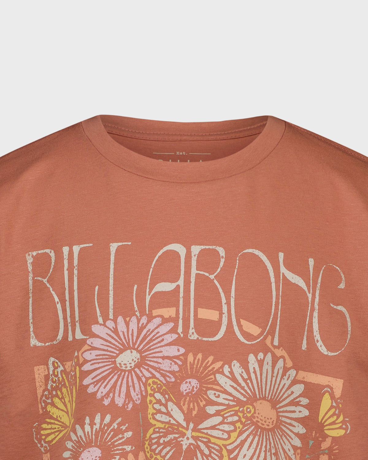 Orange t-shirt with 'Billabong' logo and floral designs on a light gray background