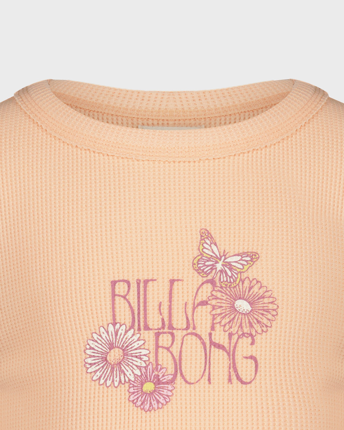 Close-up of a peach-colored shirt with floral designs and 'Billa Bong' text.