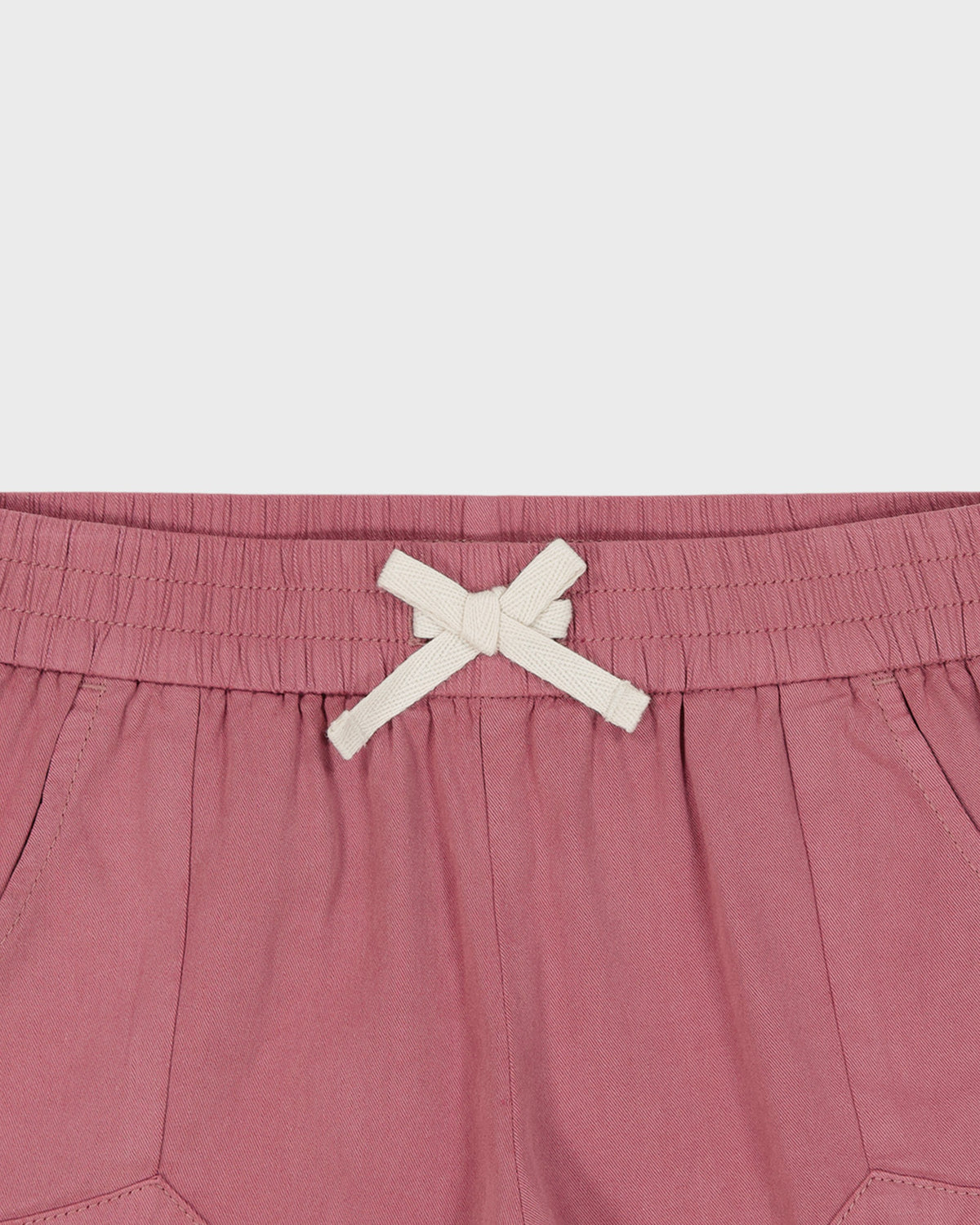 Pink shorts with a white drawstring on a light gray background