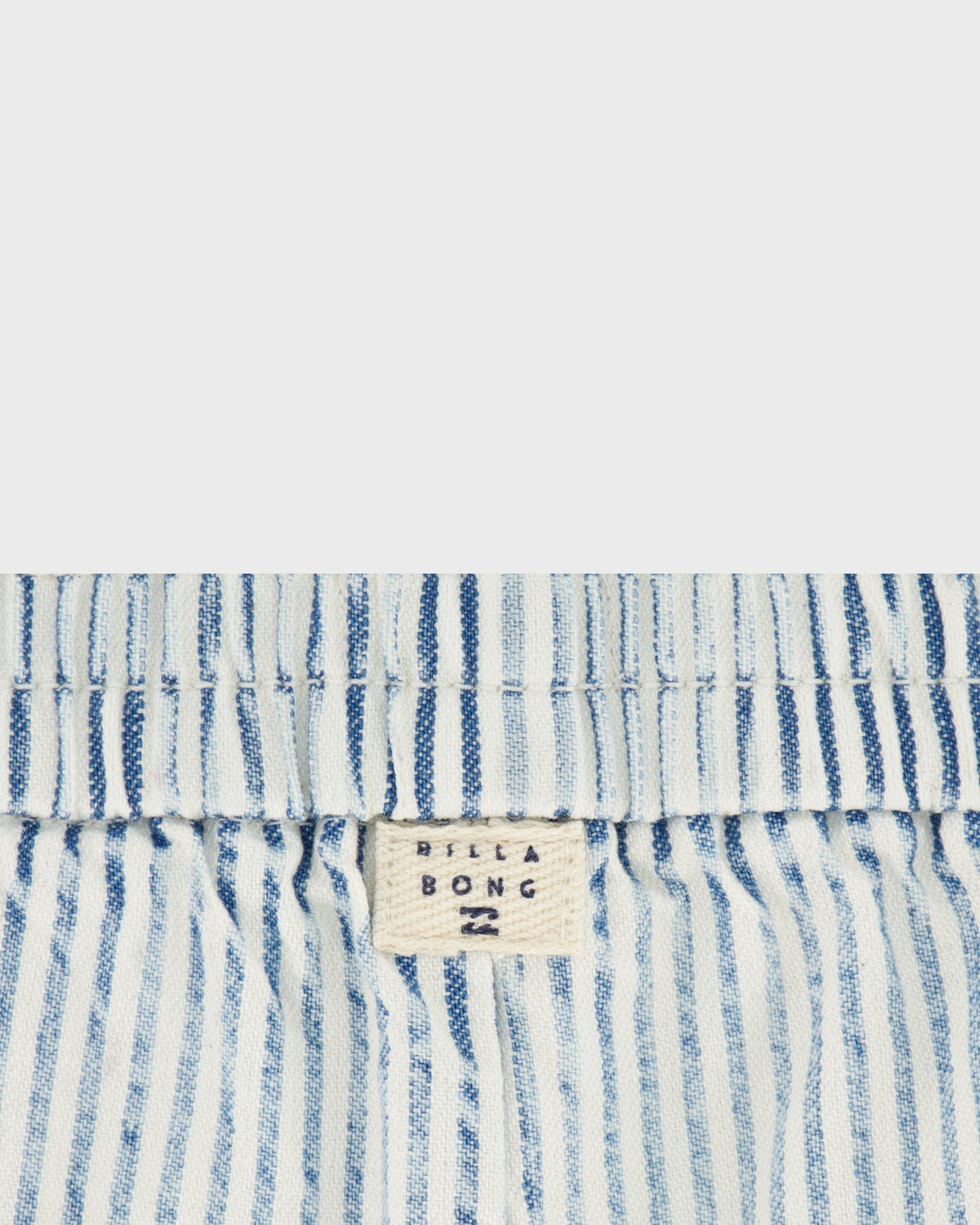 Close-up of blue and white striped fabric with a visible brand label.