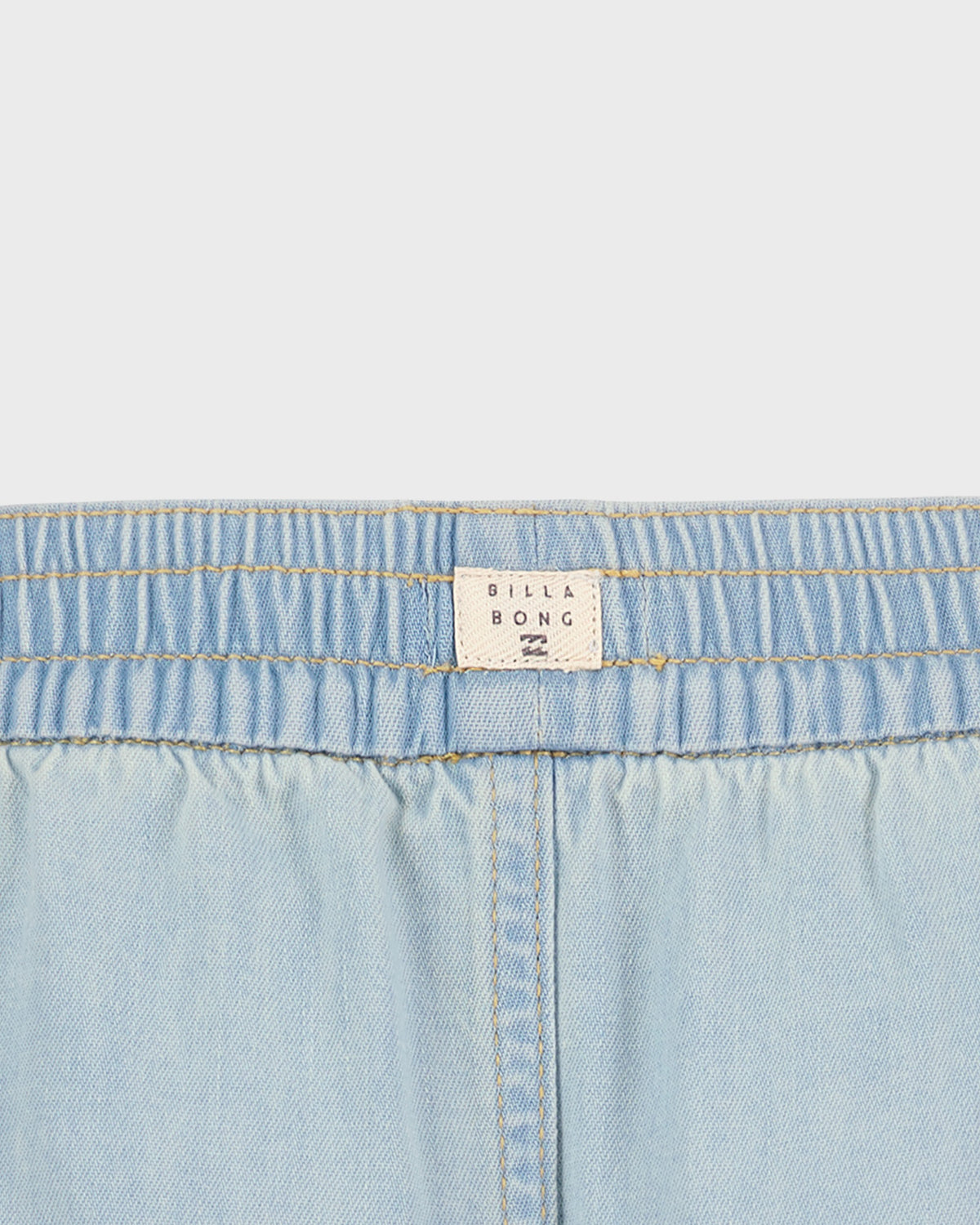Close-up of light blue denim fabric with a Billabong label.
