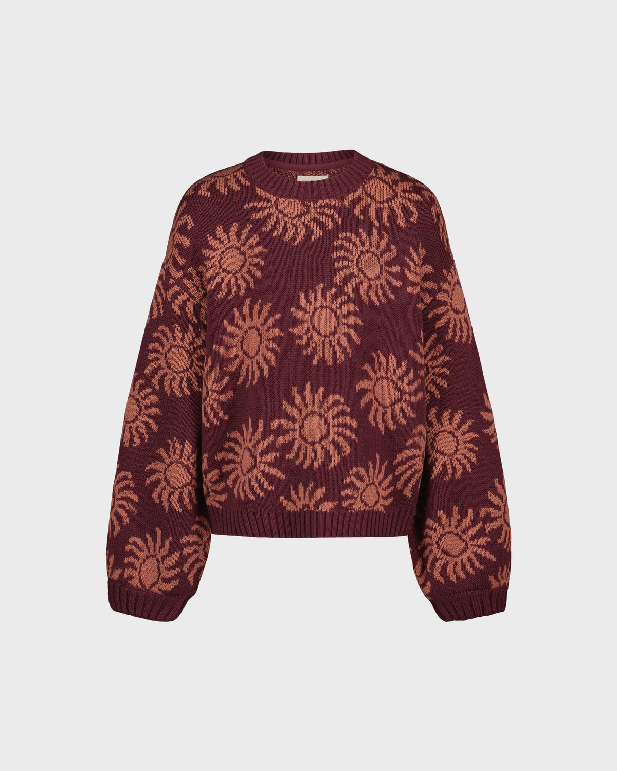 Maroon sweater with sun pattern on a light gray background