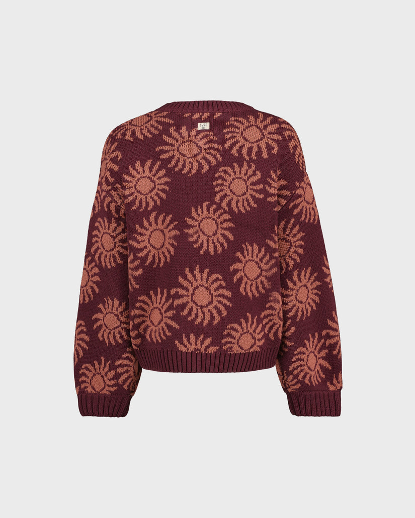 Maroon sweater with sun pattern on a light gray background