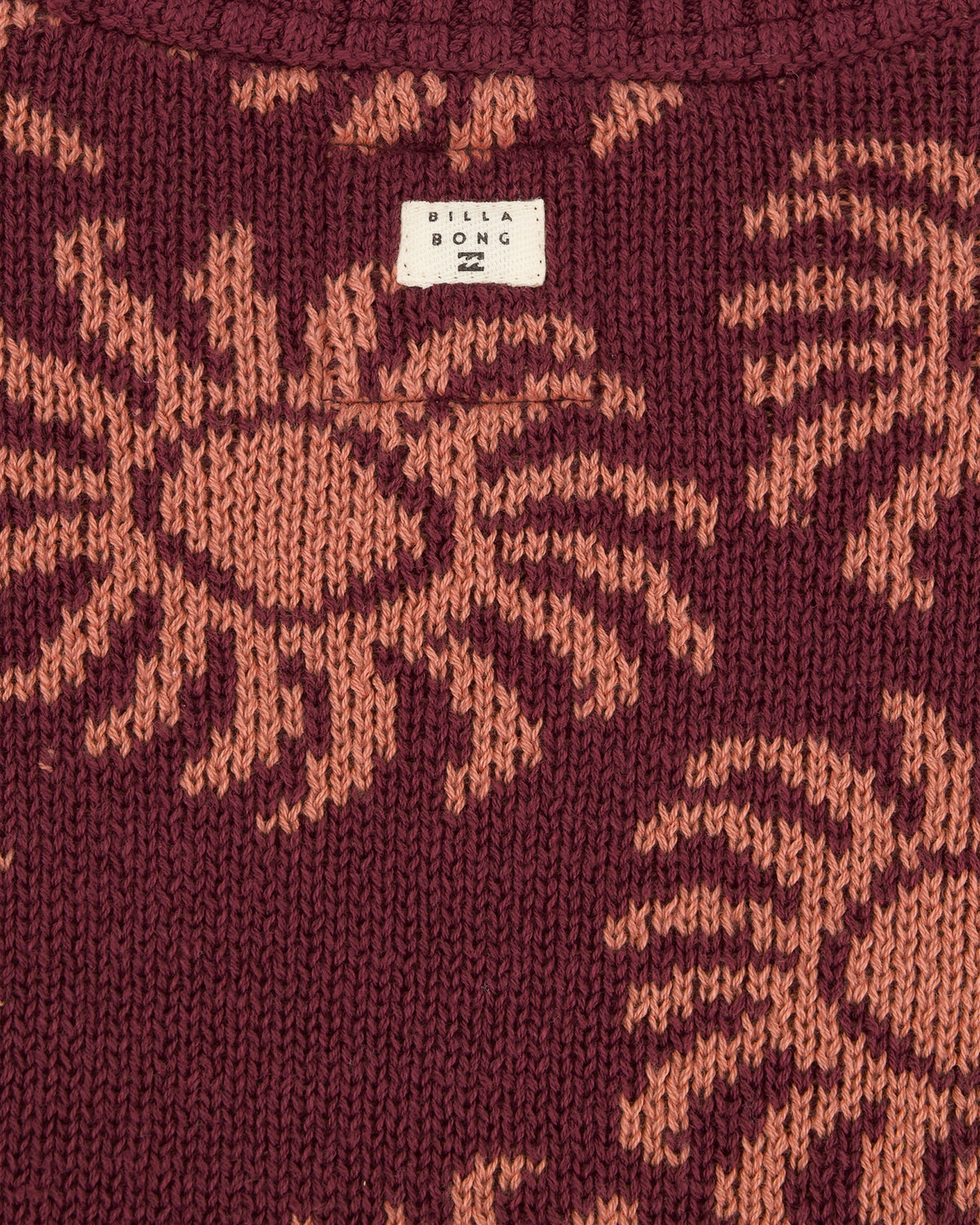 Close-up of a maroon knitted fabric with a pattern and Stella Bong label.
