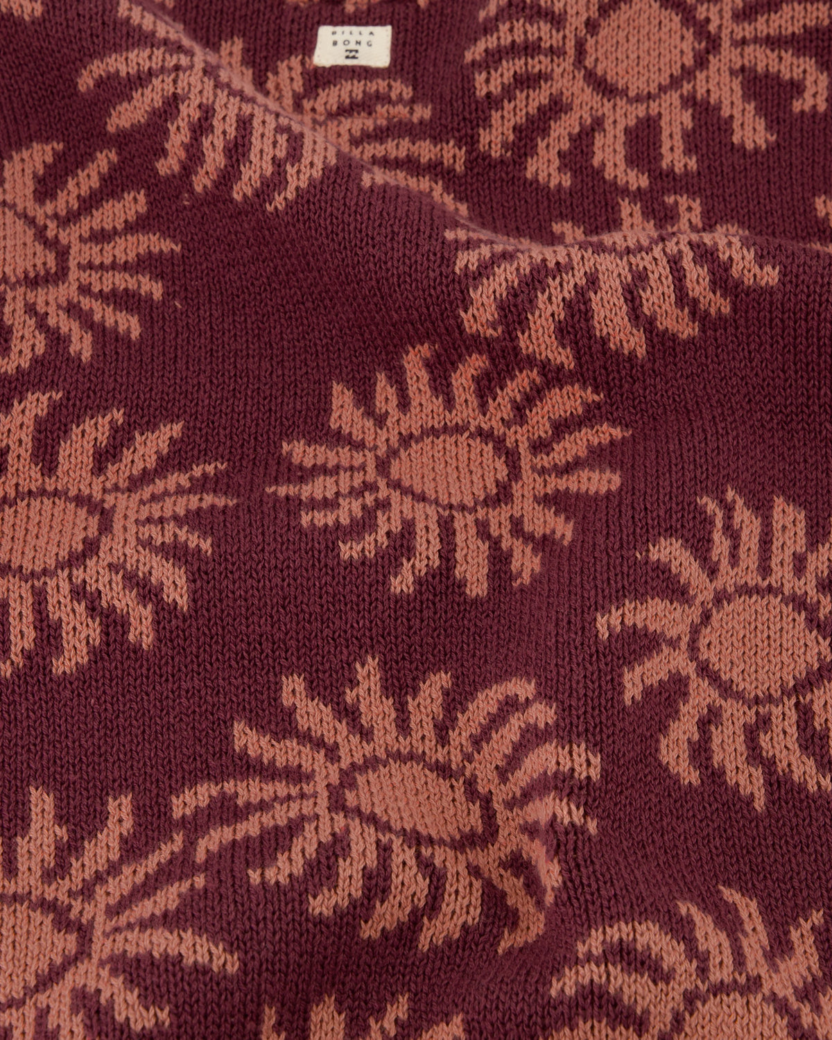 Close-up of a fabric with sunflower pattern on a maroon background