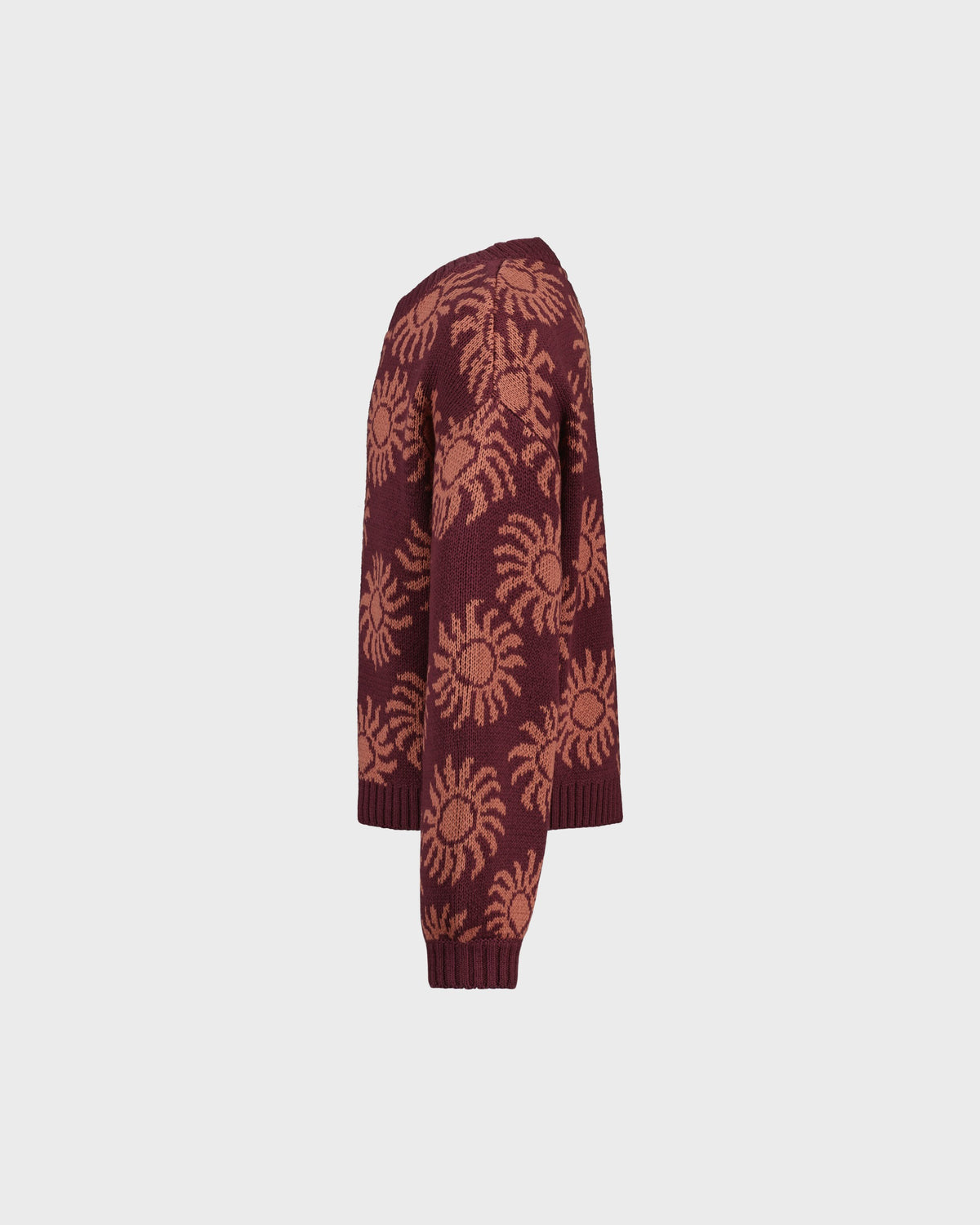 Maroon cardigan with sun pattern on a light gray background