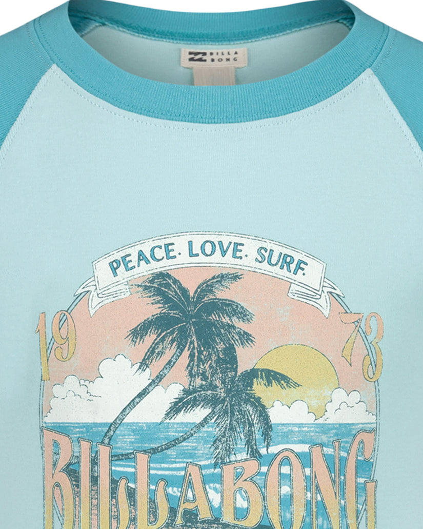 Turquoise and light blue raglan t-shirt with "Peace. Love. Surf" banner, palm tree, ocean, and sun graphic.