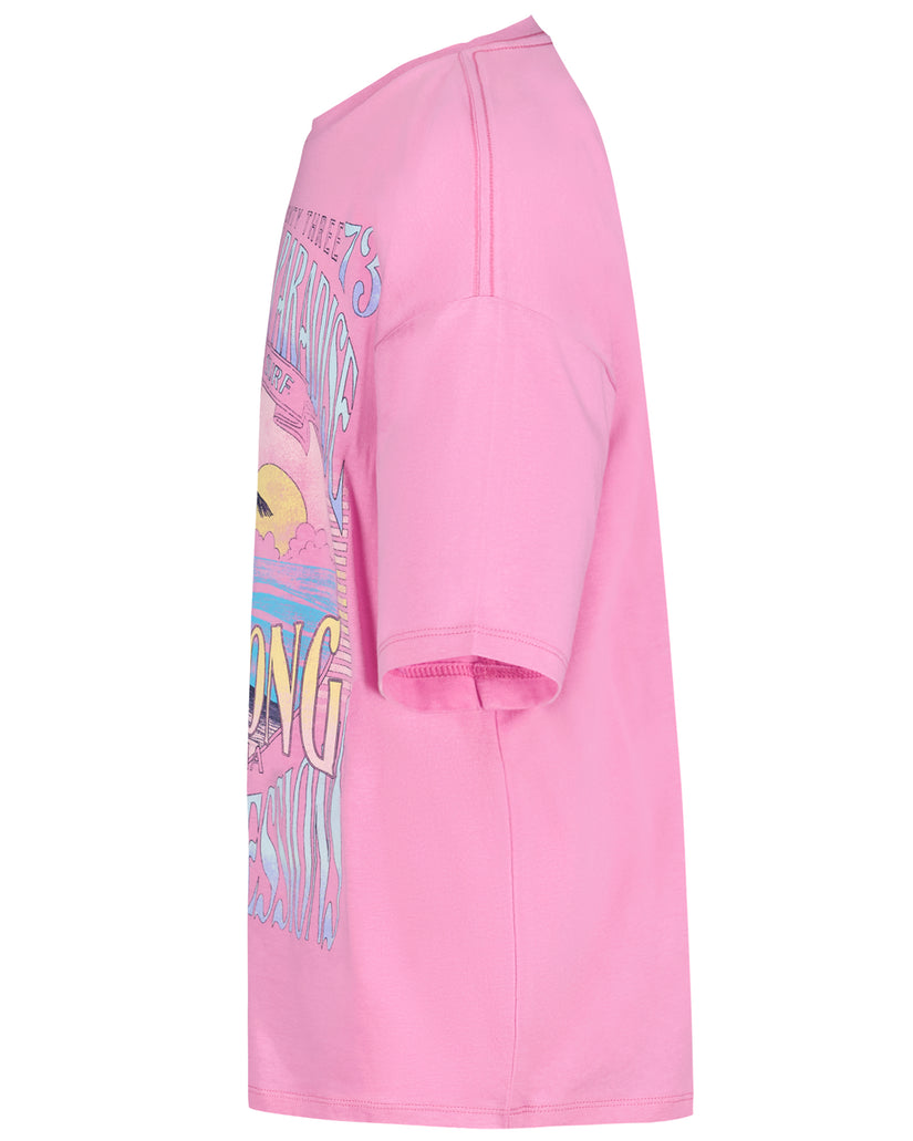 Pink oversized t-shirt with colorful sunset and palm tree graphic design on front.