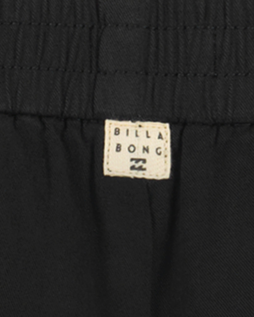 Black shorts with elasticated waistband and Billabong brand label visible.