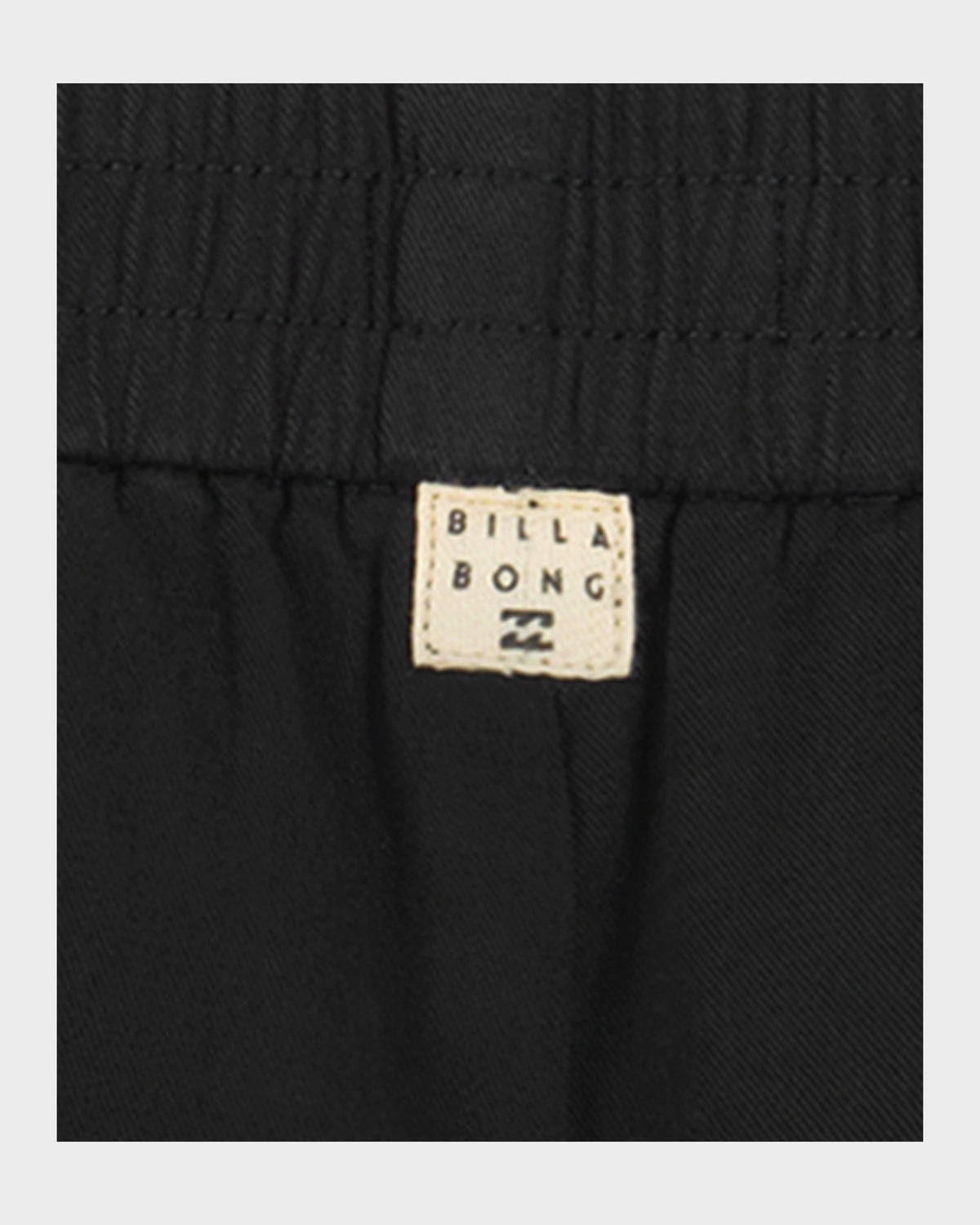 Black shorts with elasticized waistband and Billabong brand label visible.