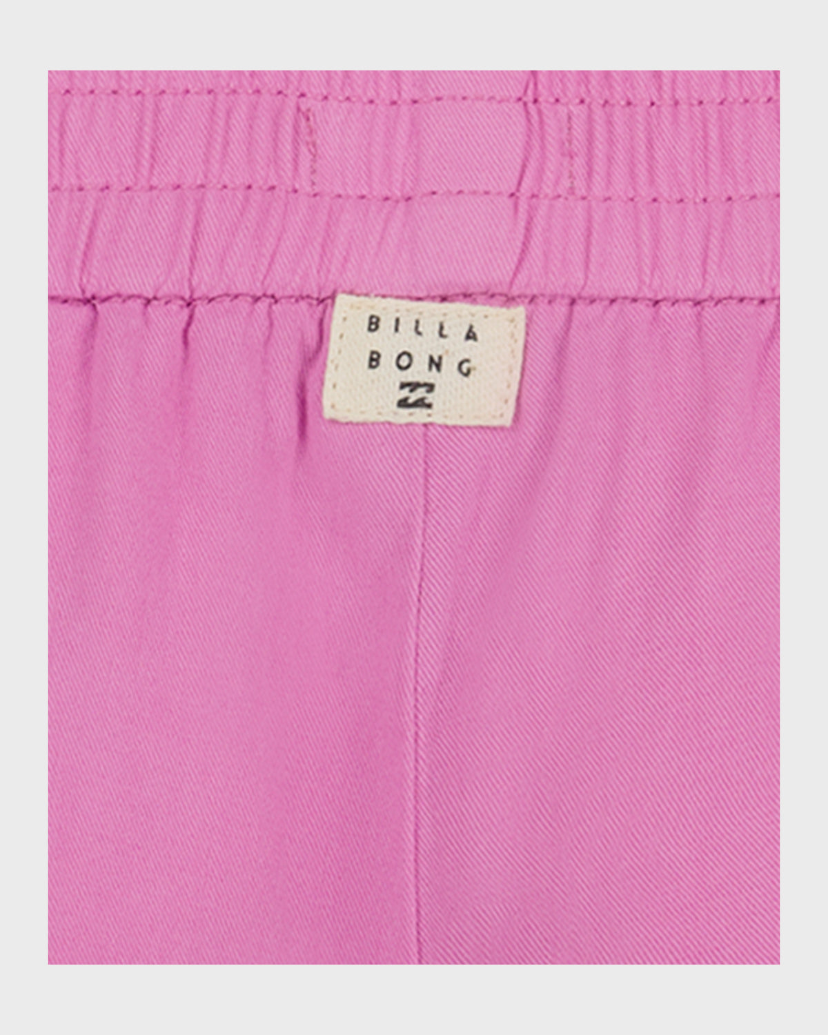 Pink shorts with elastic waistband and Billabong brand label visible on the back.