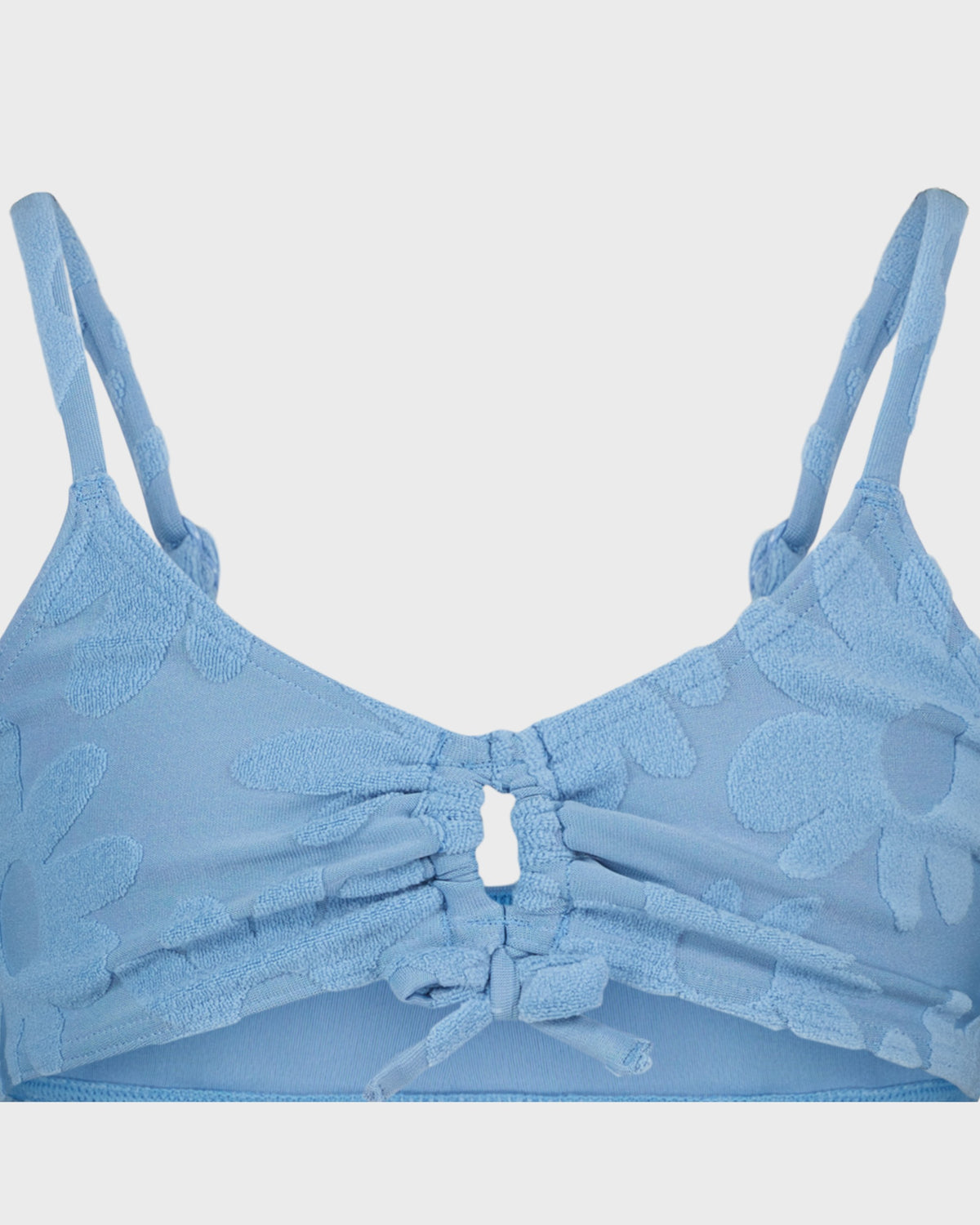 Blue bra with floral patterns on a light gray background