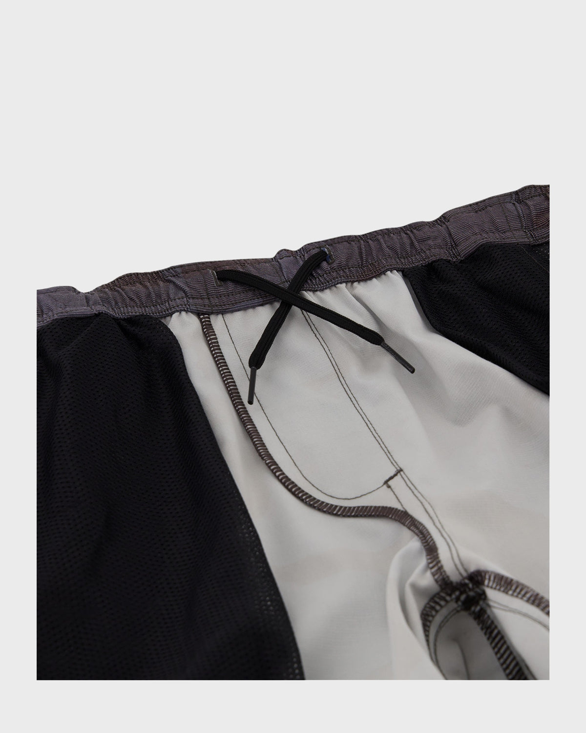 Black and white hybrid shorts with elastic waistband and black drawstring closure.