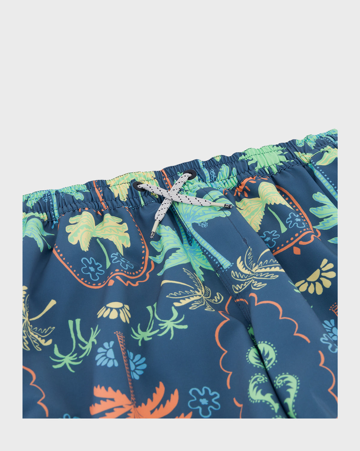 Navy swim trunks with tropical floral print in green, yellow, and orange, featuring an elastic waistband with white drawstrin