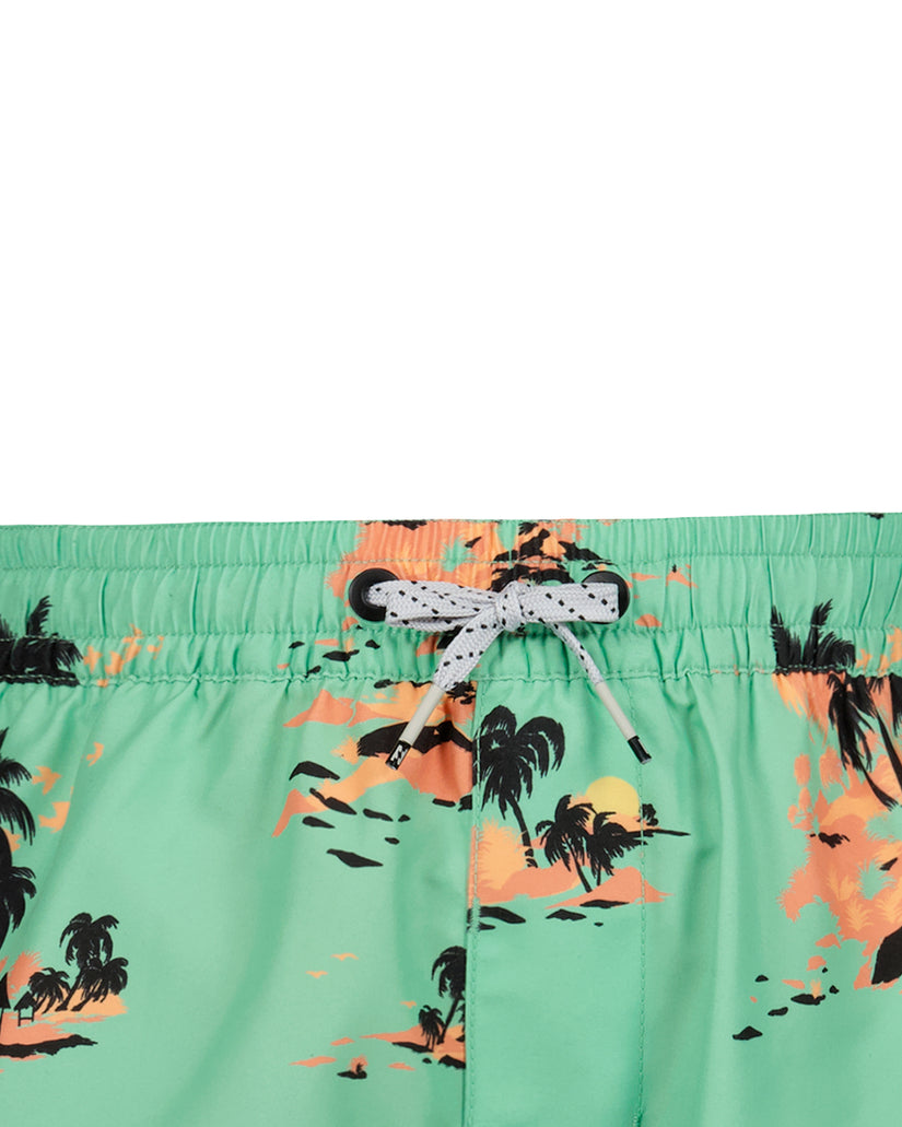 Green swim trunks with orange and black tropical sunset and palm tree print, white drawstring closure.