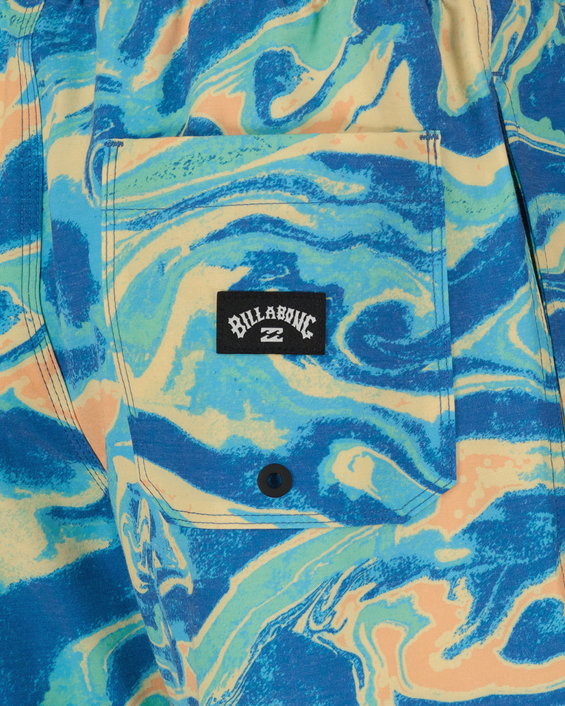 Blue, cream, and peach swim trunks with abstract swirl pattern and Billabong brand label on front pocket.