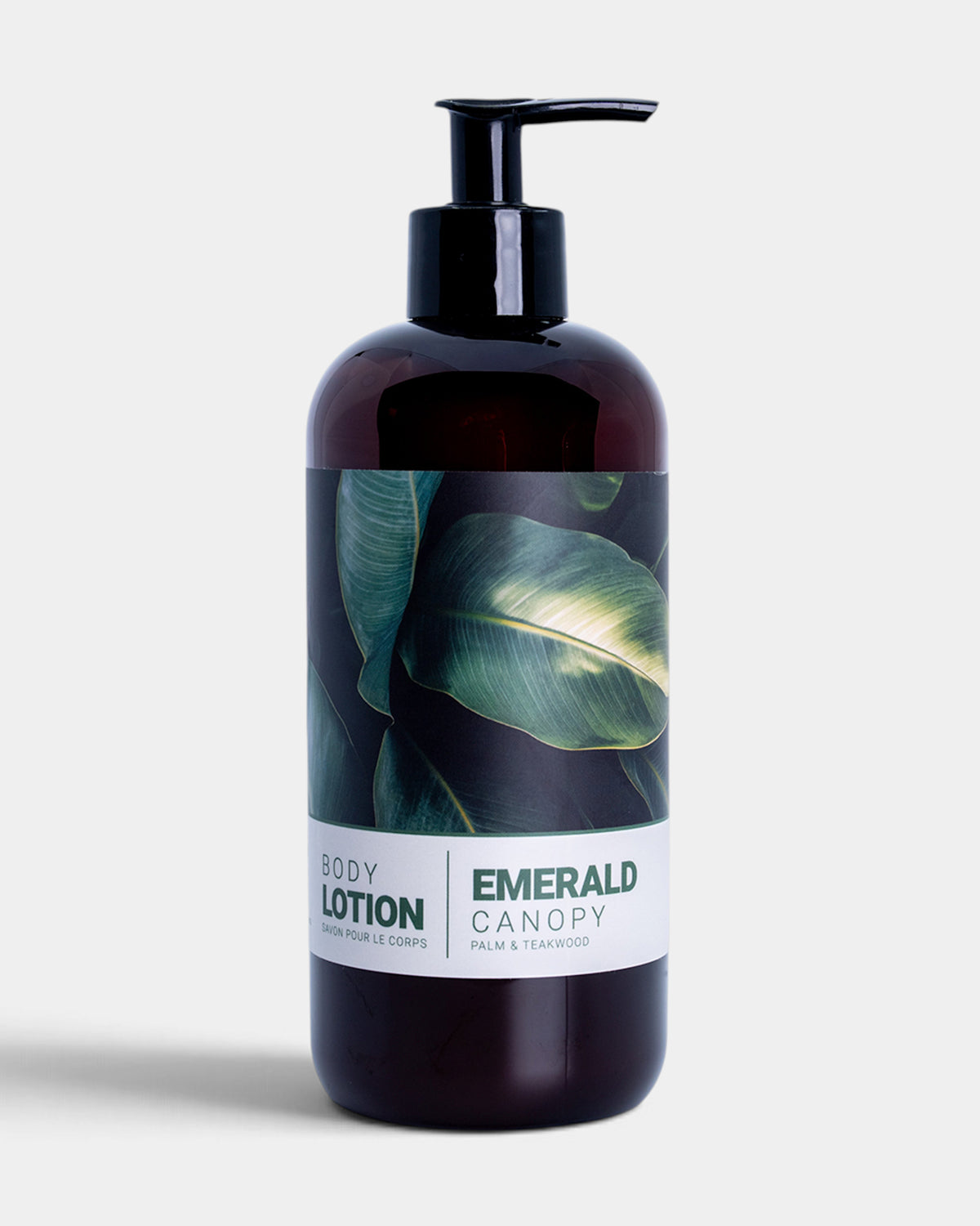 A dark amber-brown pump bottle of Emerald Canary body lotion with a black dispenser and a label featuring green tropical leaves, set against a light gray background.